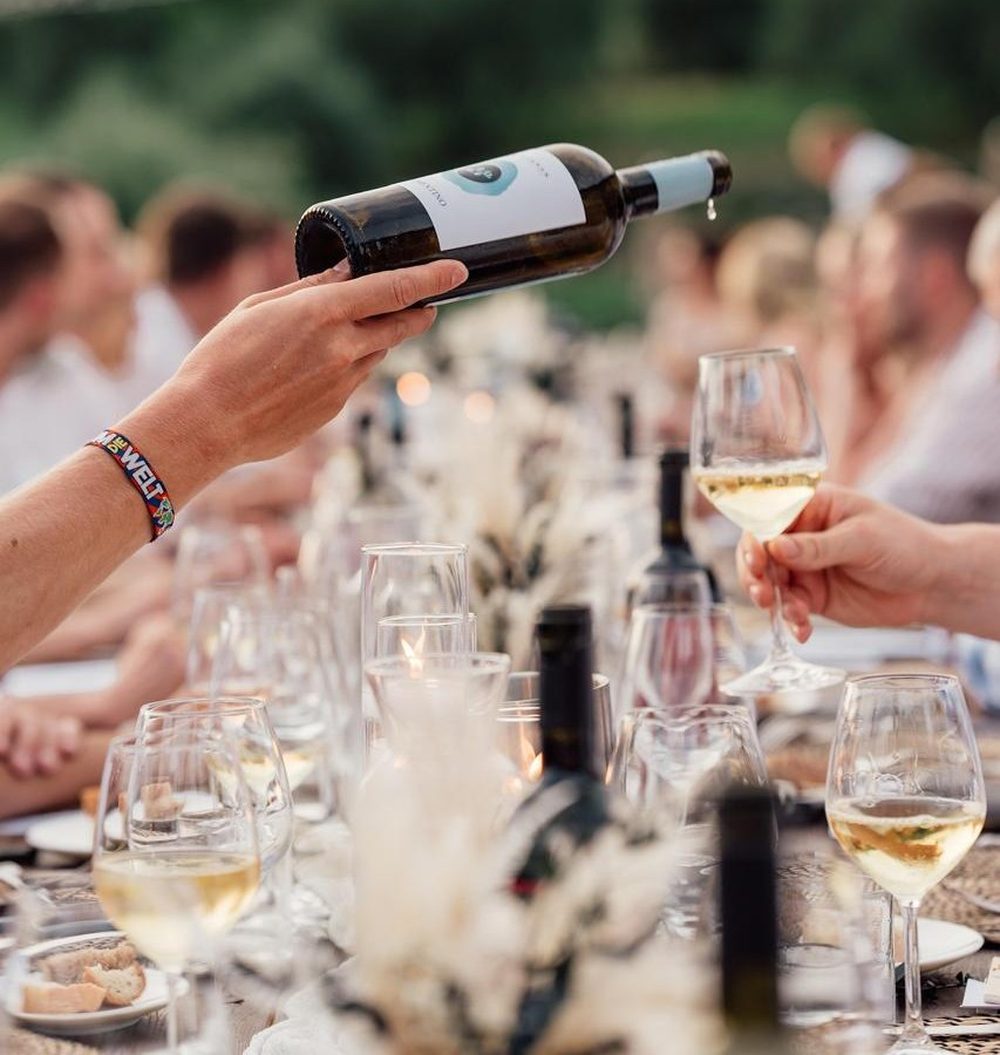 Wine being poured at an outdoor dinner during a South Africa motorcycle tour